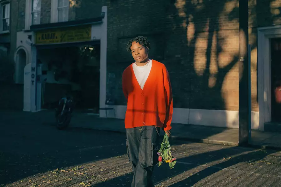 Lei Hope stood on a street, wearing a red cardigan and holding a bunch of flowers
