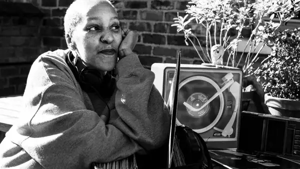 Andrea trout sat in a garden with a record player and laptop