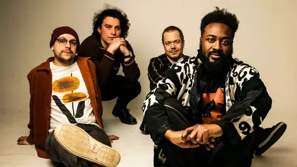 4 members of the band good grief relaxed sitting on the floor