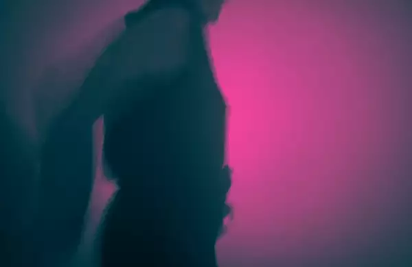 A silhouette of someone dancing in a club