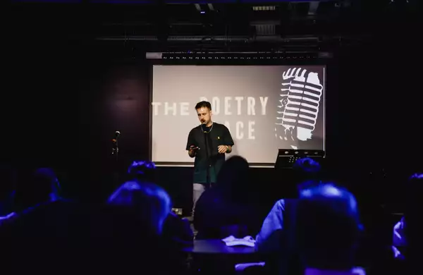 Photo of a poetry slam event with a poet on stage