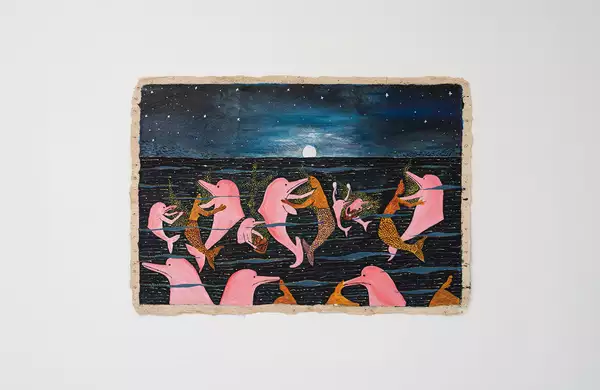 An artwork by Santiago Yahuarcani, showing dolphins and mermaids. The artwork is displayed on a white wall.