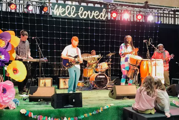 Sens Sagna & the Kajamor Family perform on stage while two children watch