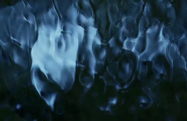 This image has an abstract, fluid-like pattern with deep blue and black tones, creating a sense of flowing water or rippling textures.