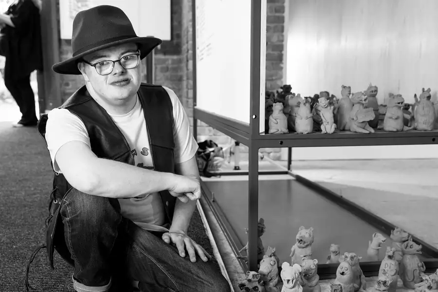 Black and white photograph of Dominic Bennett with his terracotta weasels