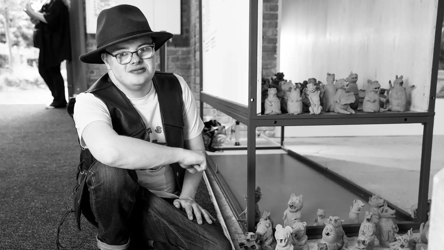 Black and white photograph of Dominic Bennett with his terracotta weasels