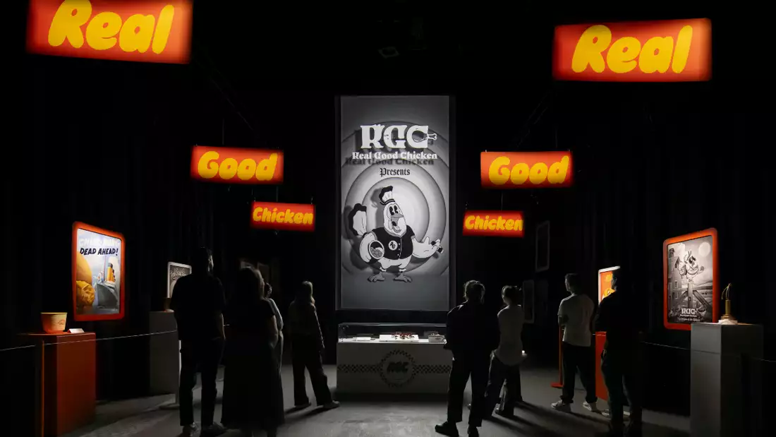 Silhouettes of people in front of a bright room of exhibited art and merchandise